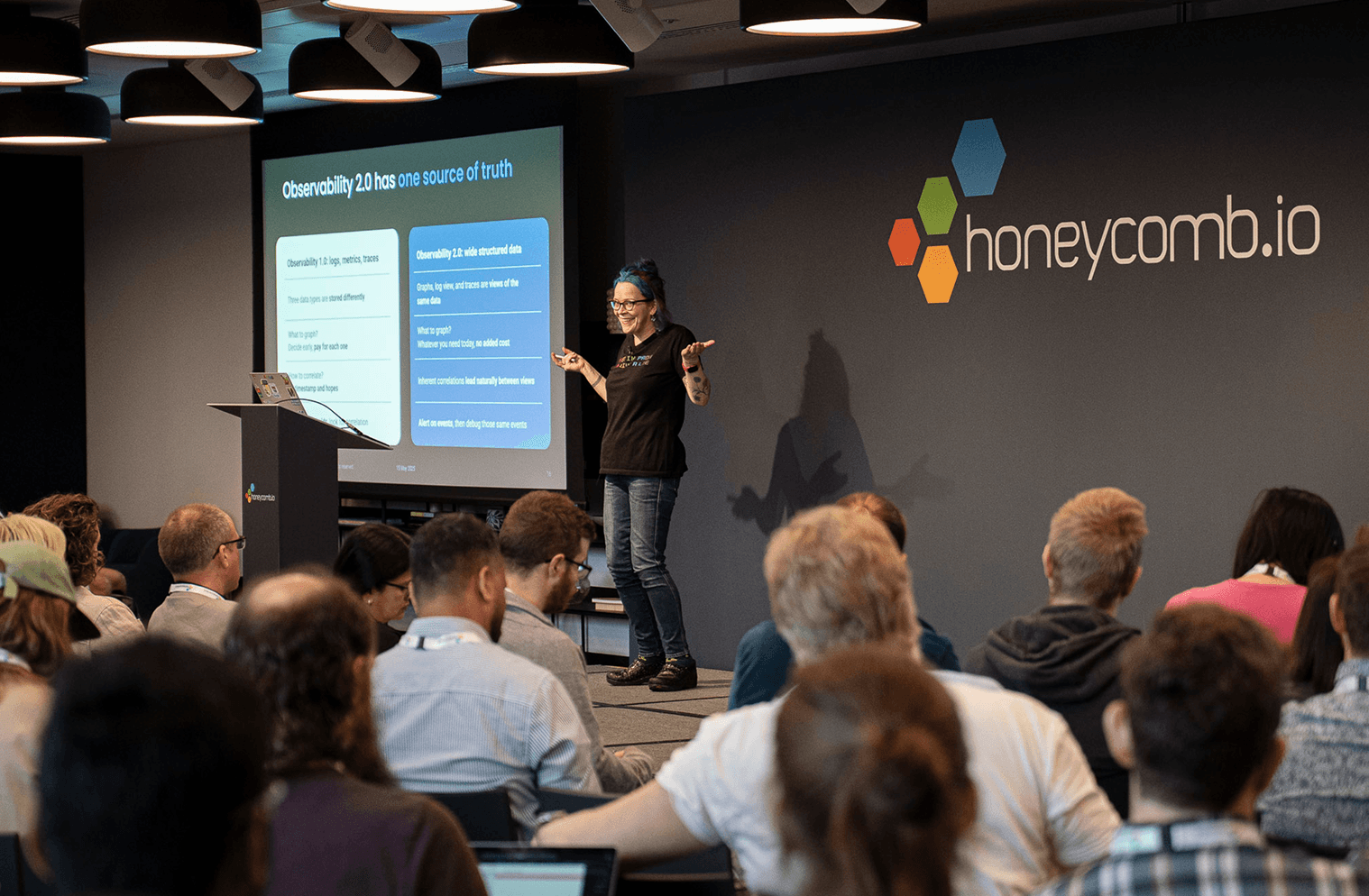 Charity Majors on stage with Honeycomb.io logo