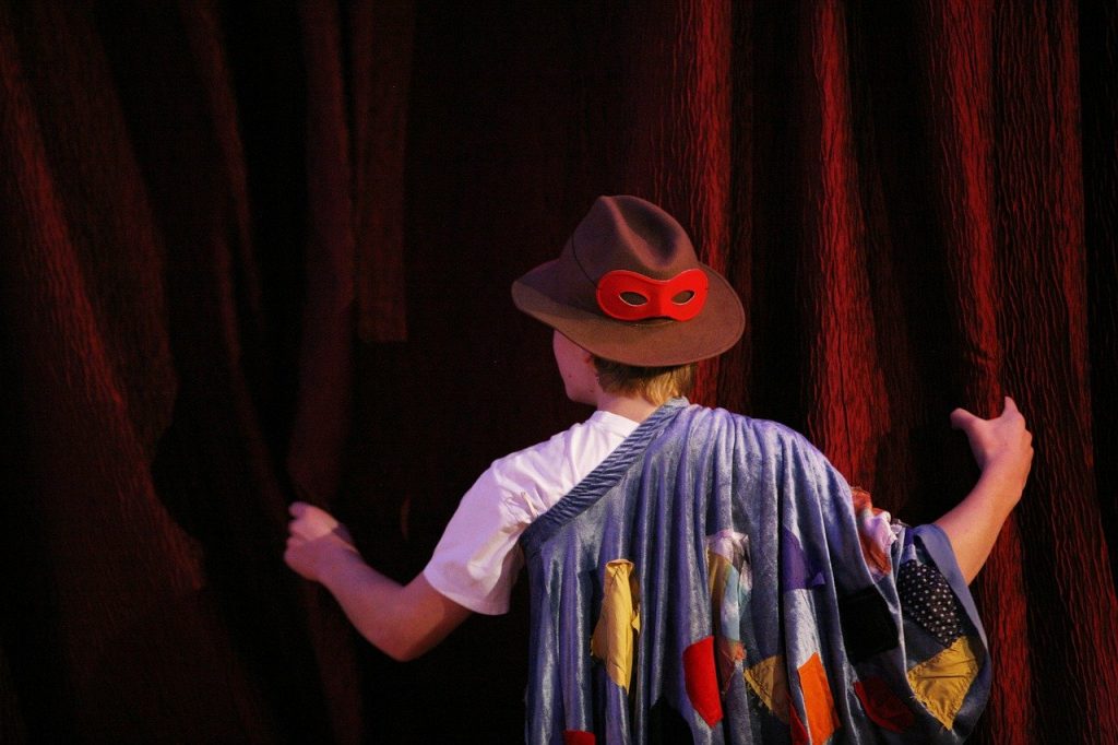 Person in costume looking behind a curtain