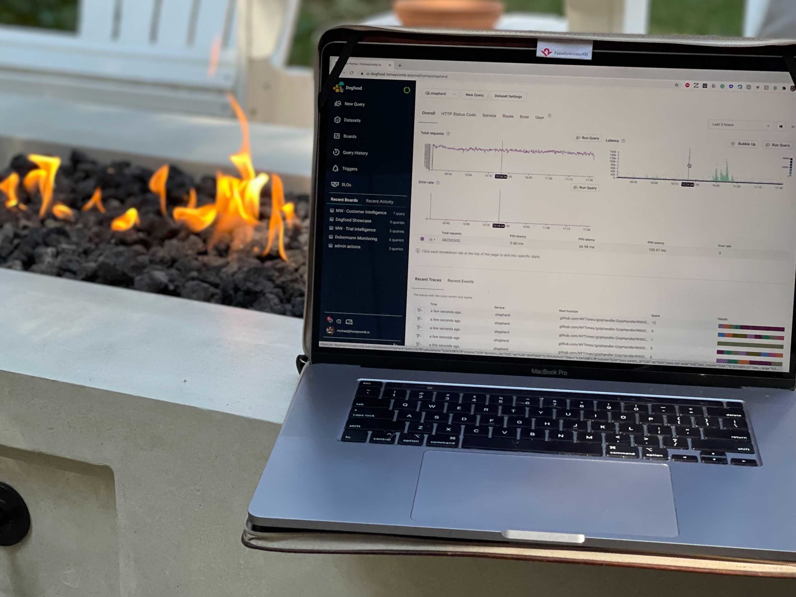 laptop in front of an outdoor fireplace showing the Honeycomb home page with data