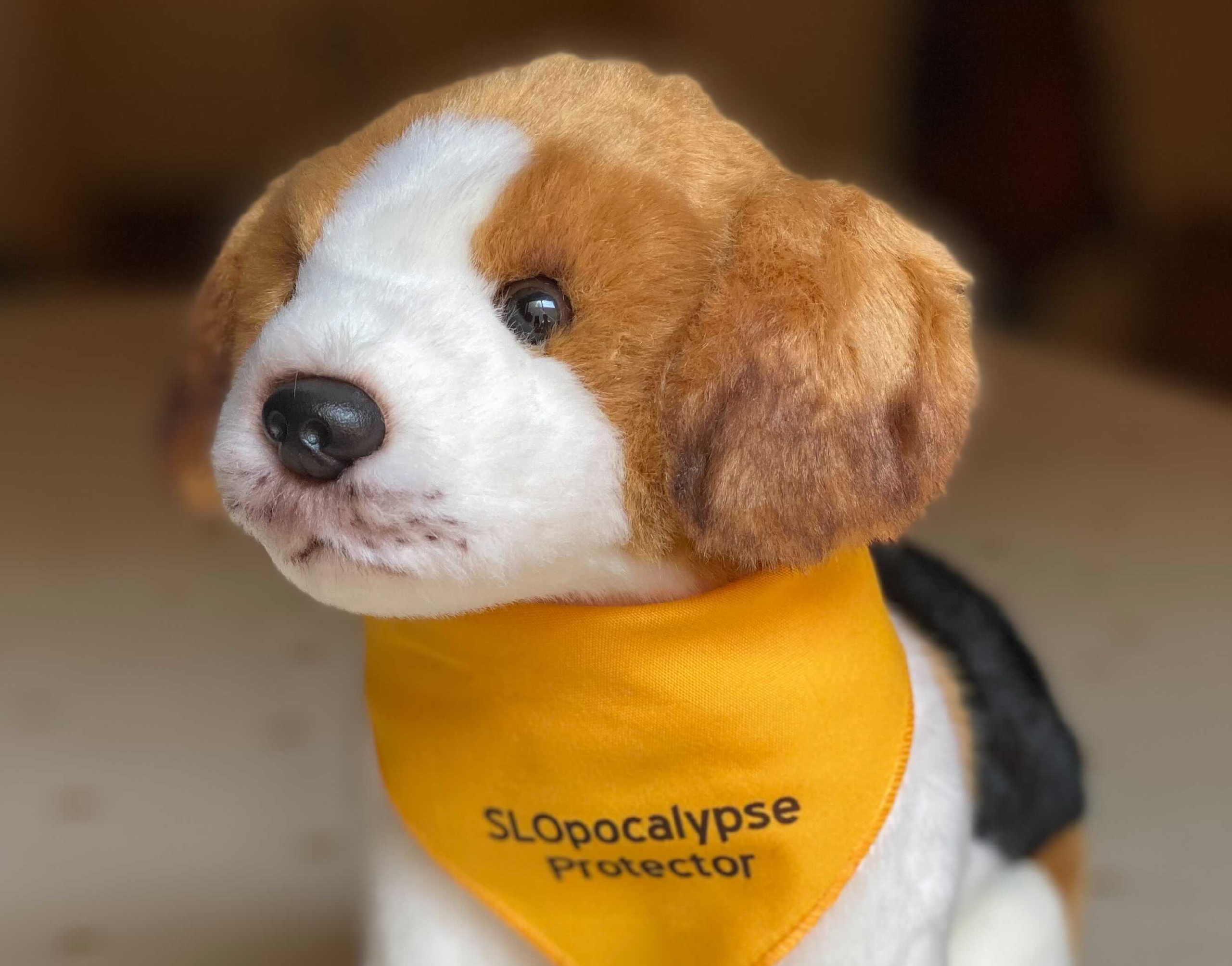 stuffed animal dog wearing yellow bandana with the text "SLOpocalypse Protector"