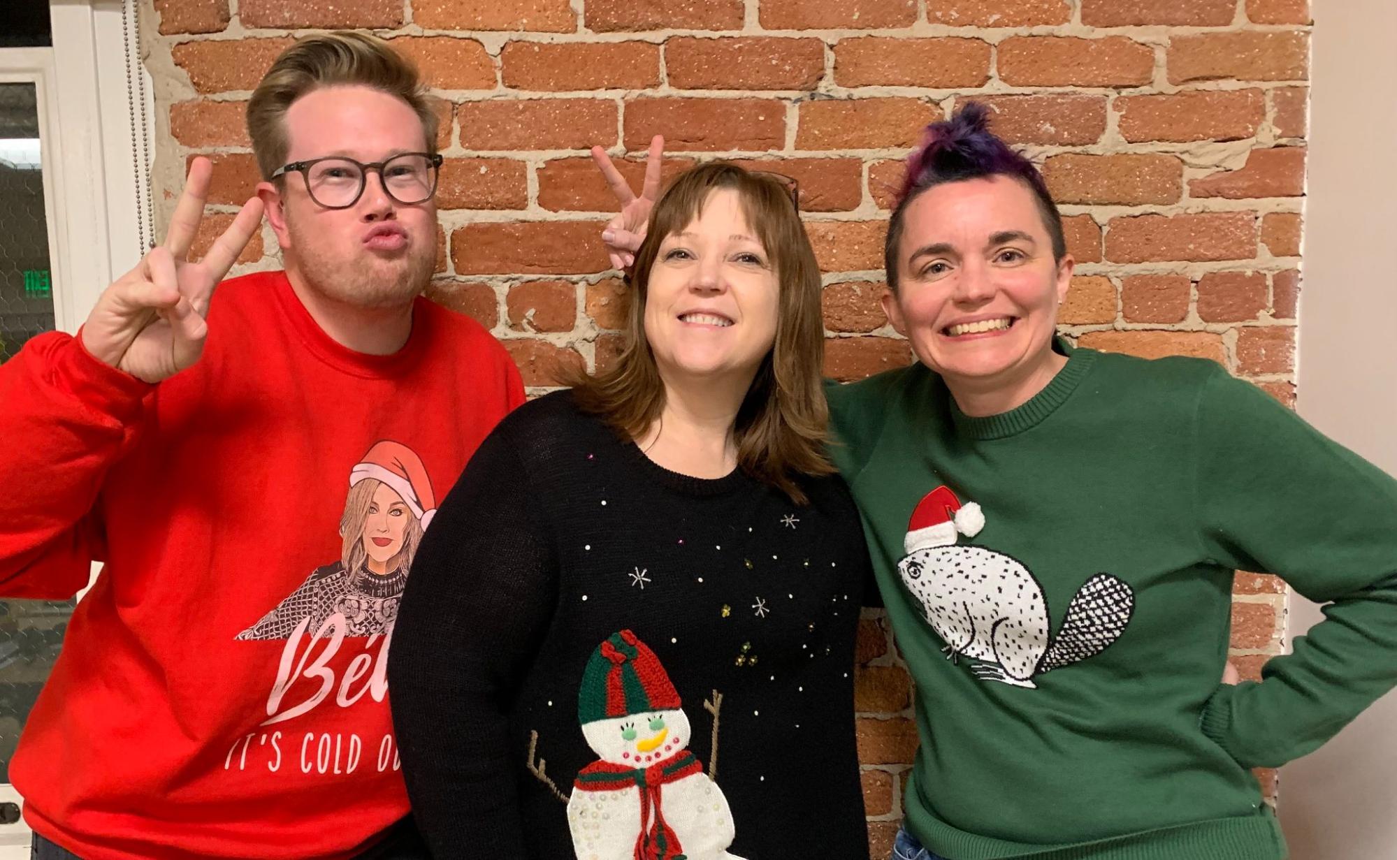 Harrison Calato, Jo Ann Sanders, and Jessica Kerr show off their ugliest Christmas sweaters at the Honeycomb office.